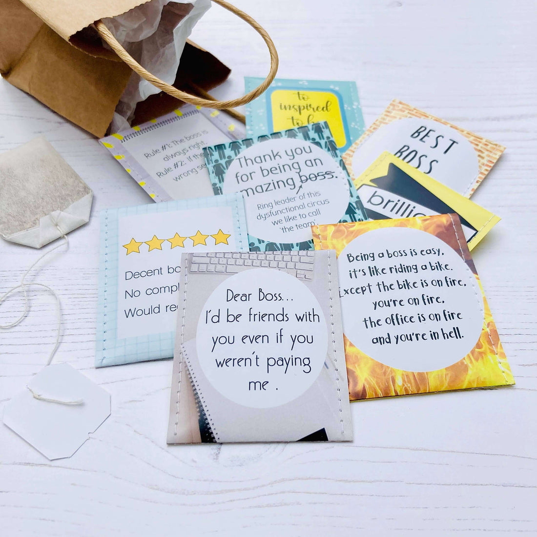 Flat lay of colorful cards with appreciation quotes for bosses, displayed with a paper bag.