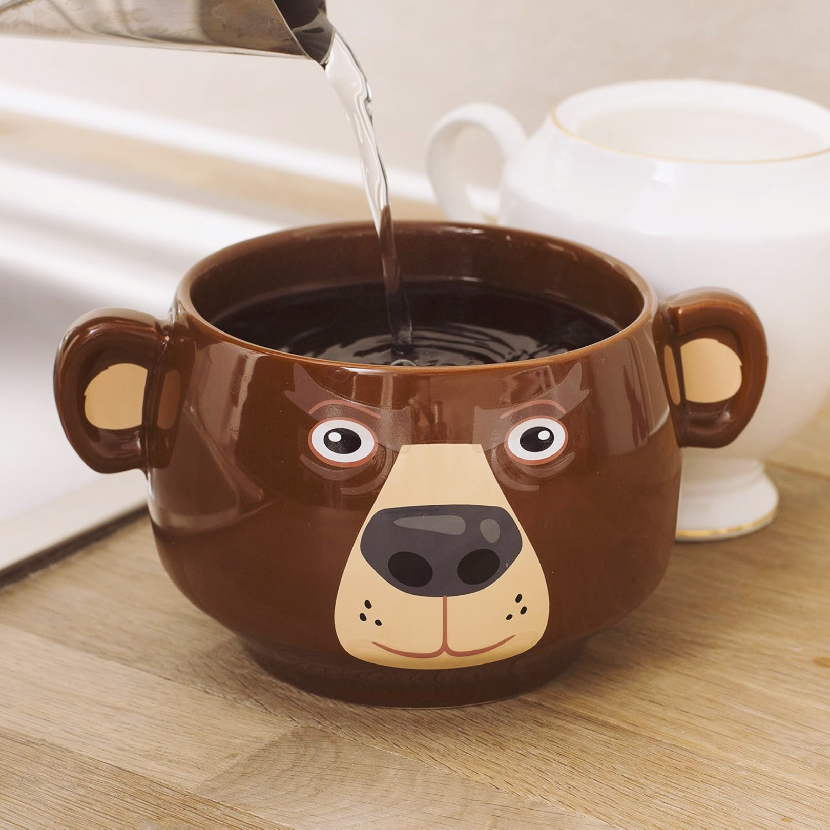 Bear Heat Change Mug with water being poured into it, showcasing its playful bear design.
