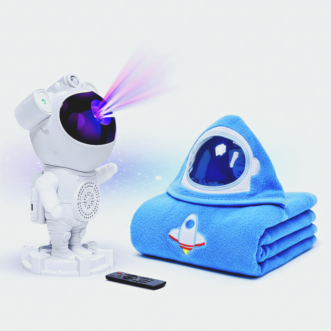 Toy astronaut with projector and blue blanket with space design on a white background