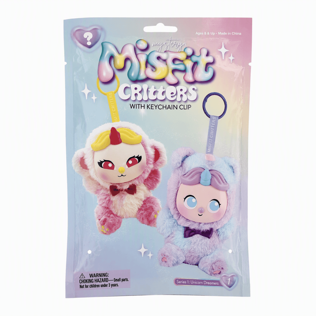 A sealed retail package for Misfit Critters with keychain clip, showing two plush unicorn-themed critters on the front. The package is light blue and pink with the Misfit Critters logo at the top and a hanging hole near the upper edge.