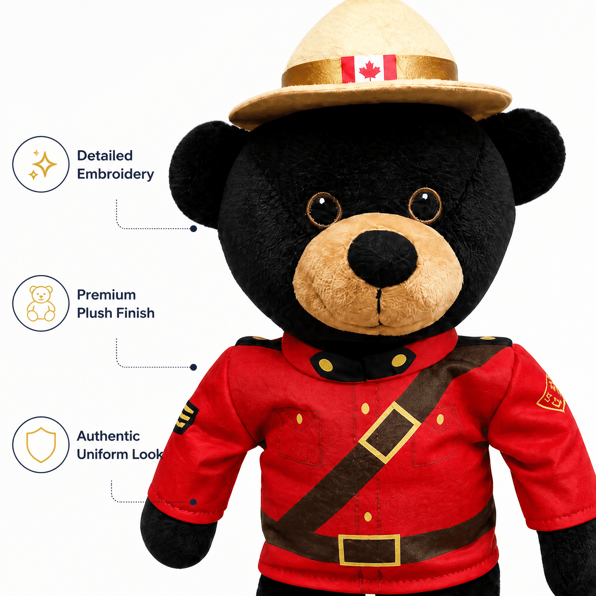 Black bear plush toy wearing a red uniform and straw hat with a Canadian flag, on a white background.