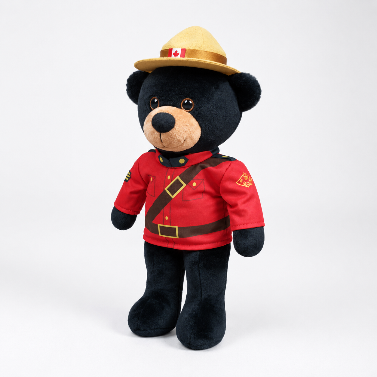 Plush bear wearing a red uniform and hat with a Canadian flag on a white background