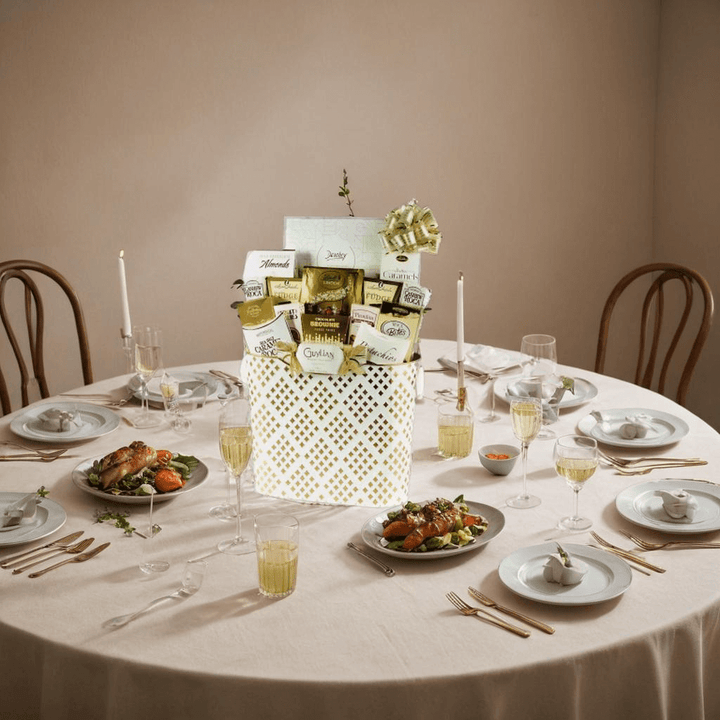 White & Gold Grandeur Gift Basket – 17 Luxurious Treats displayed elegantly on a dining table.