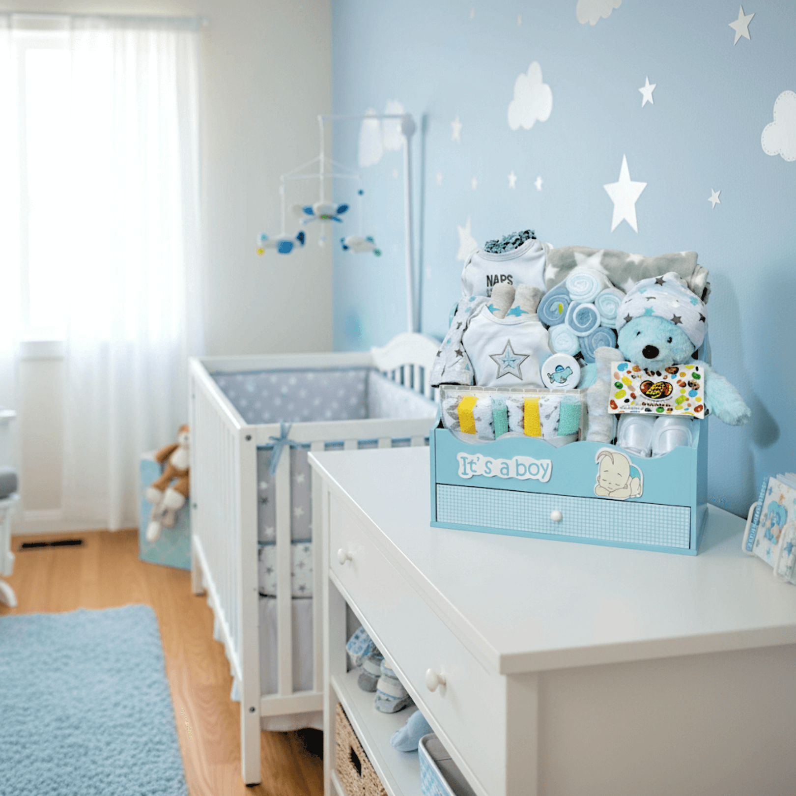Wooden Tote with Drawer (BOYS) displayed in a cozy nursery adorned with blue accents and baby items.