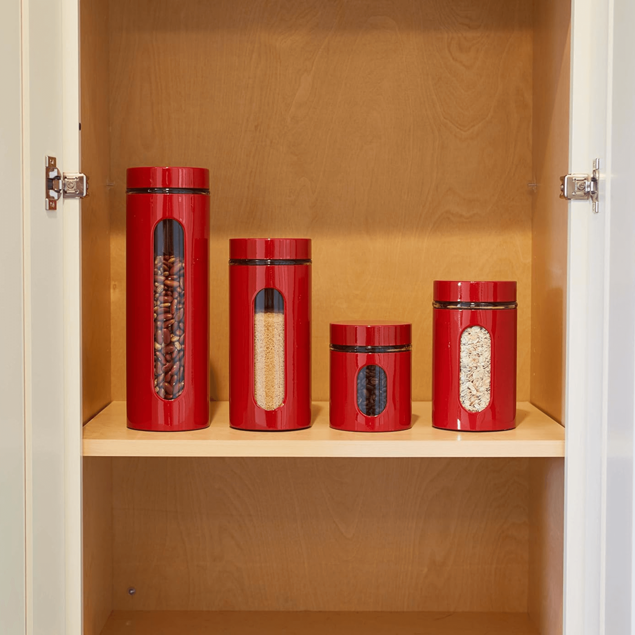 Anchor Hocking 4-piece cherry red glass canister set displayed in a kitchen cabinet with airtight lids.
