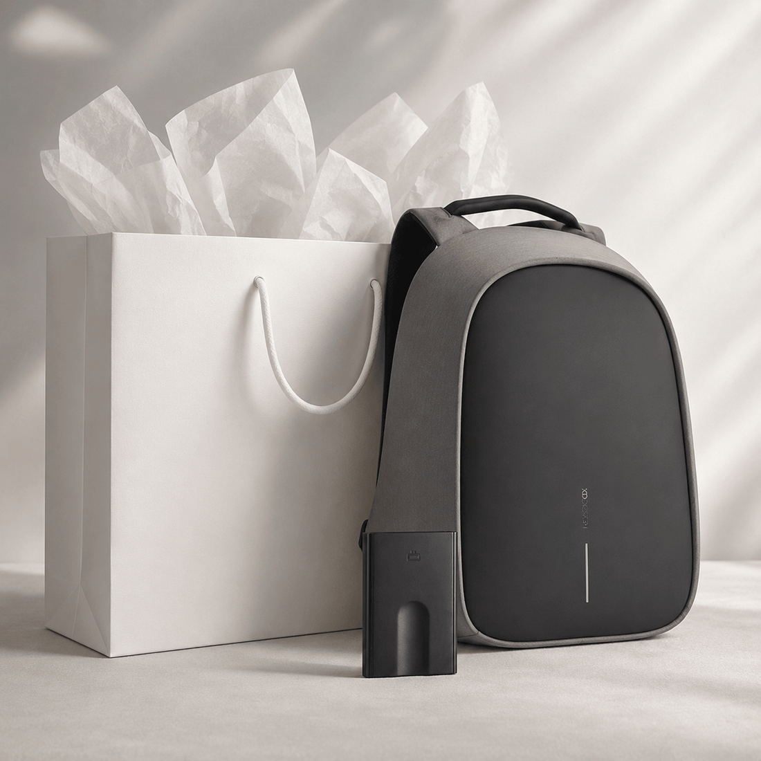 Anti-Theft Backpack and Aluminum Wallet Set displayed with a gift bag and tissue paper.