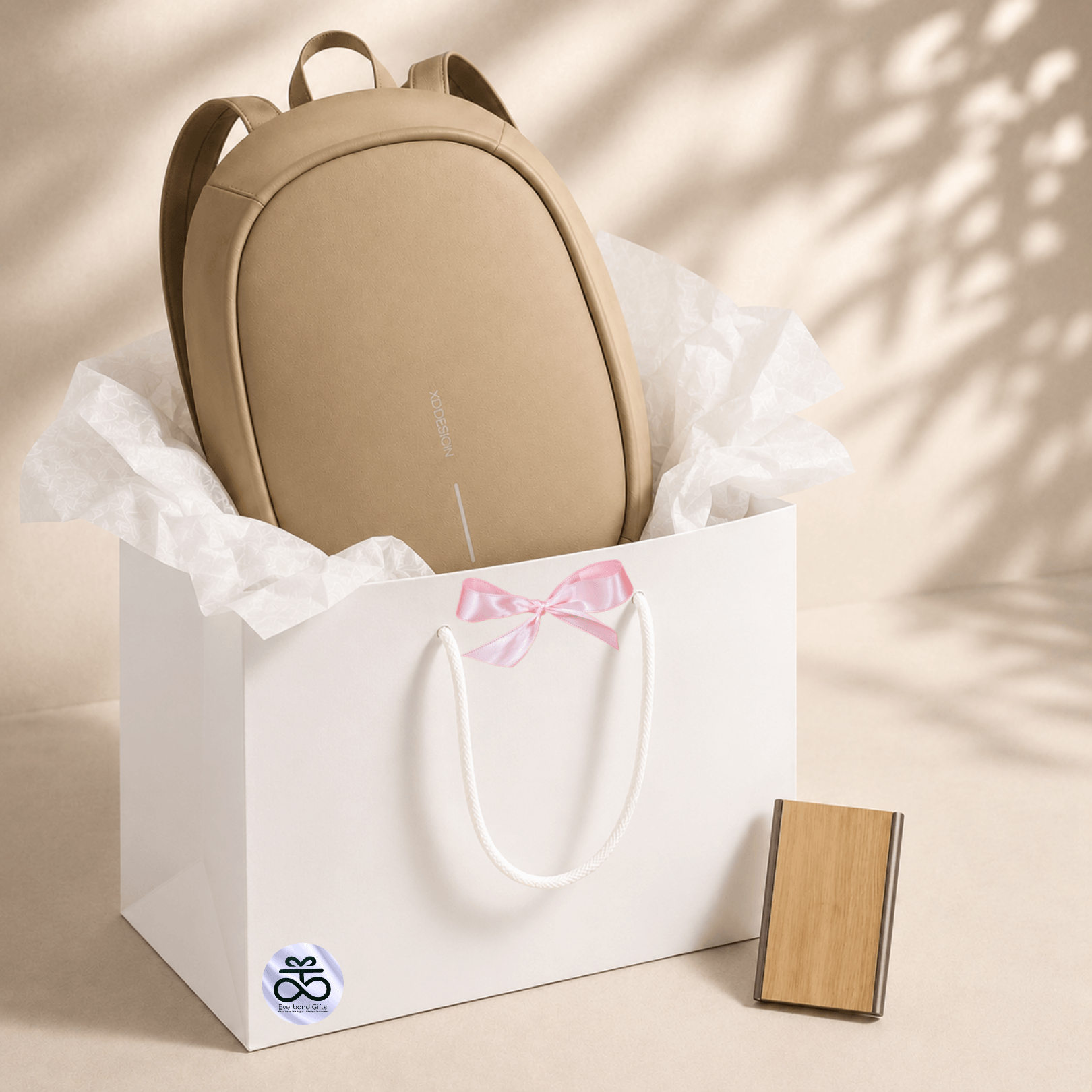 Anti-Theft Backpack and RFID Card Holder Set displayed in a gift bag with brown tissue paper.