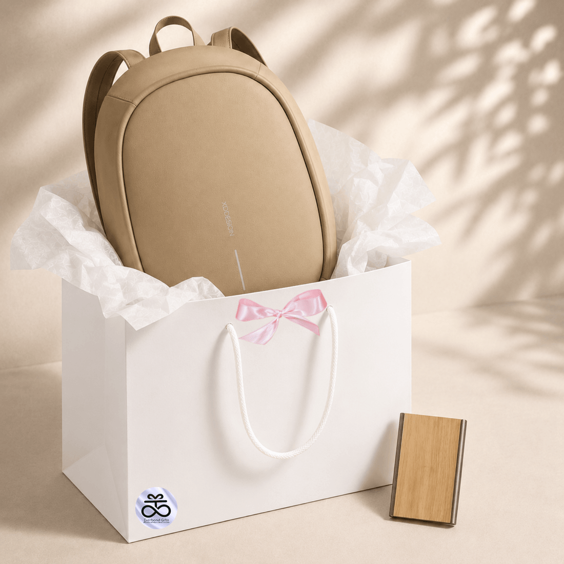 Anti-Theft Backpack and RFID Card Holder Set displayed in a gift bag with brown tissue paper.