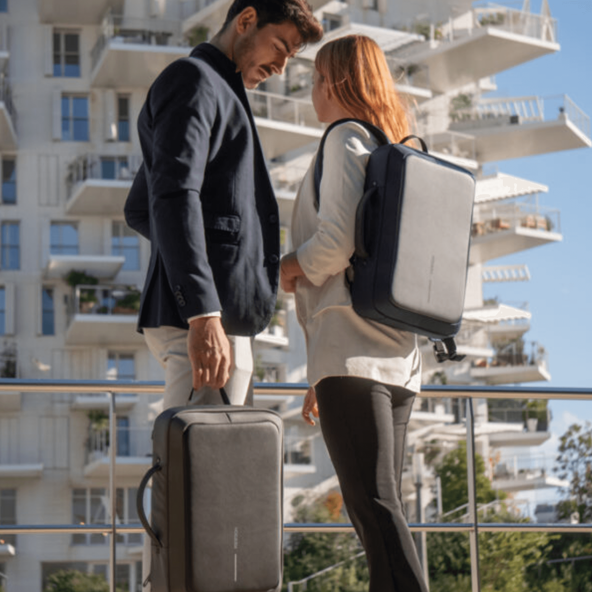 Man and woman showcasing Bobby Bizz 2.0 Anti-Theft Backpack & Briefcase in urban setting.