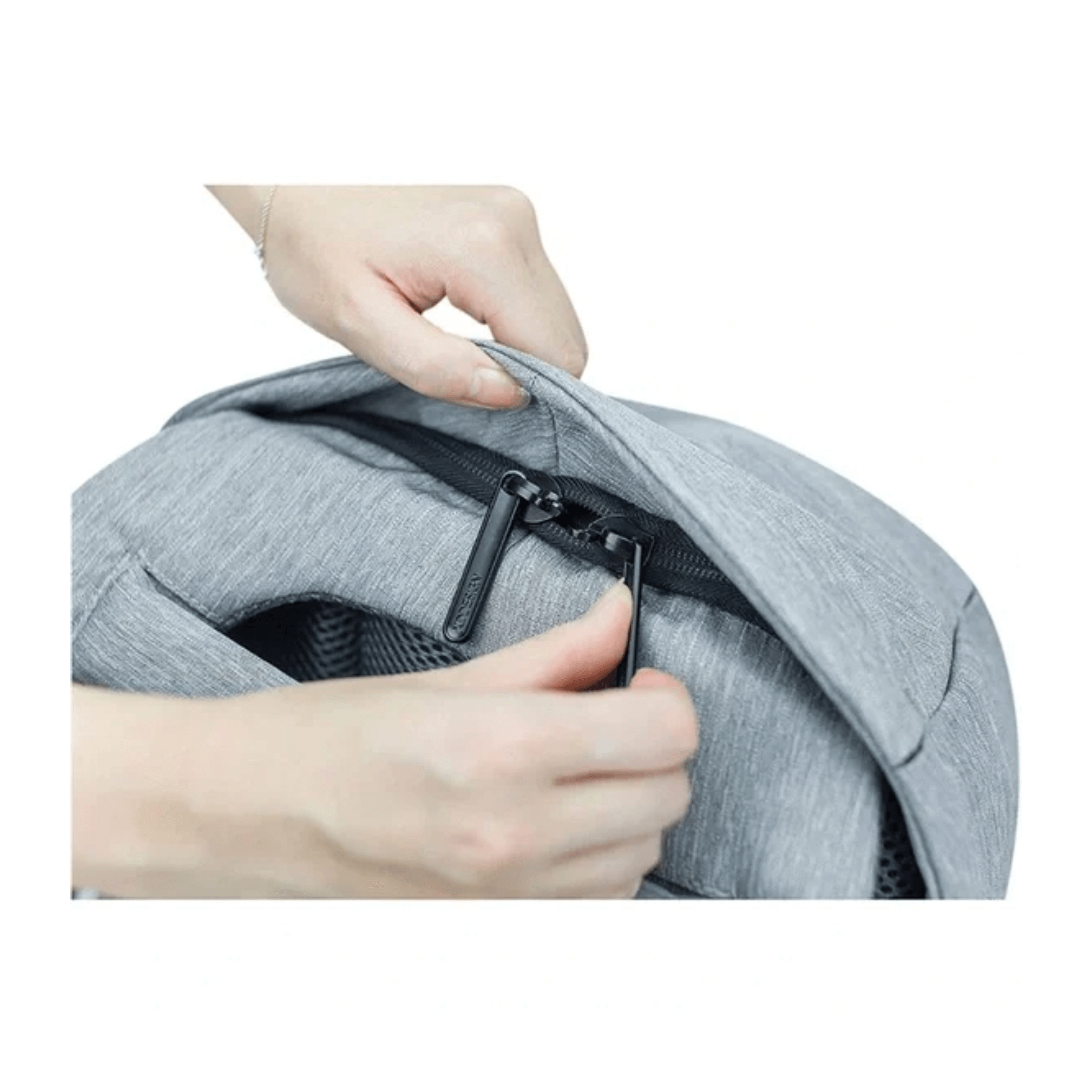 Close-up of a hand opening the zipper on the Bobby Compact Anti-Theft Backpack in gray.