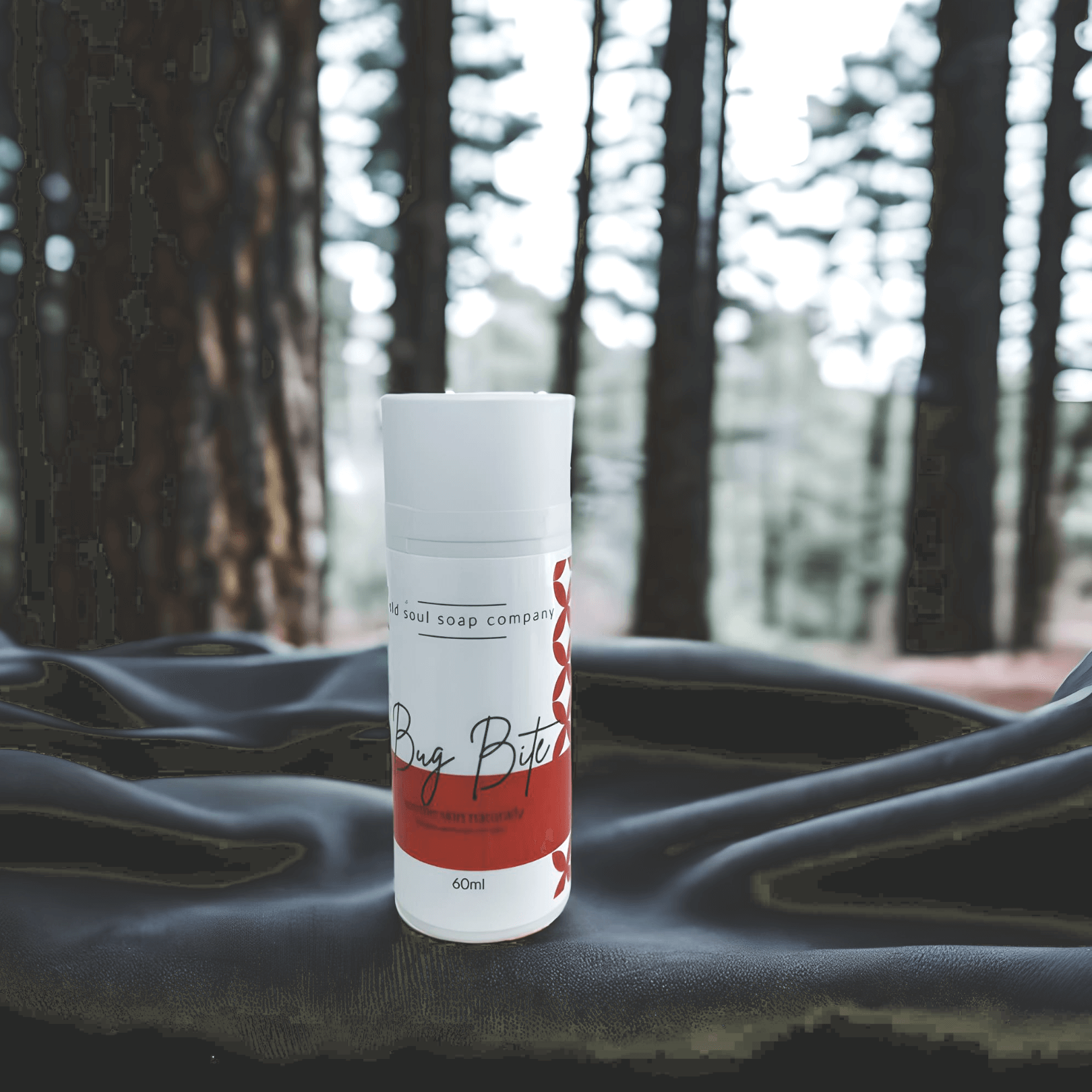 Old Soul Soap Company's Bug Bite remedy among trees, perfect for outdoor adventures and camping.