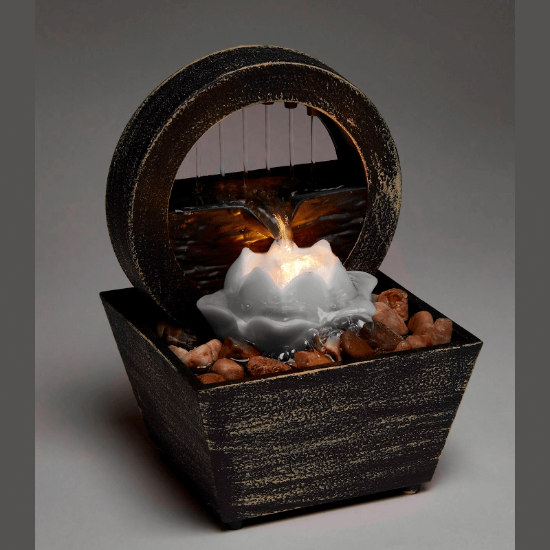 Elegant Lotus Table Fountain with LED light and cascading water over stones, promoting tranquility and relaxation.