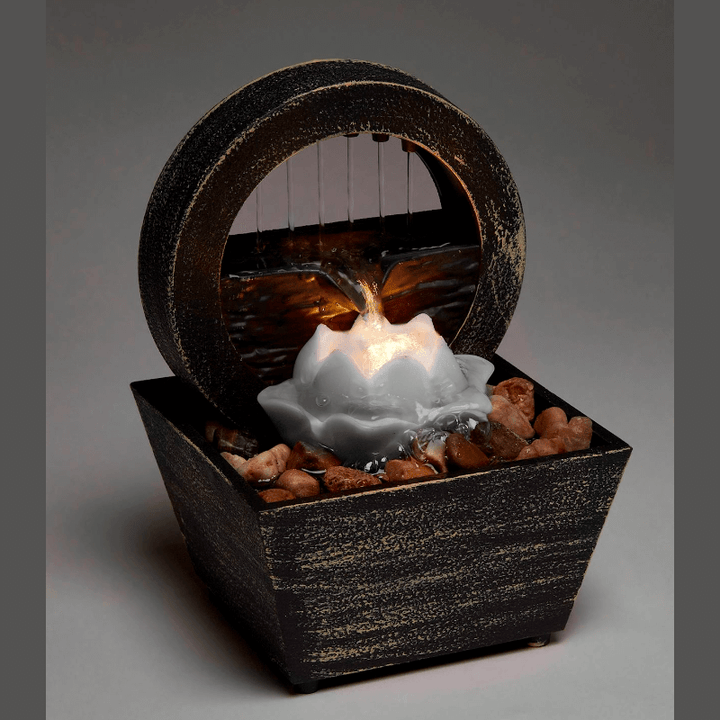 Elegant Lotus Table Fountain with LED light and cascading water over stones, promoting tranquility and relaxation.