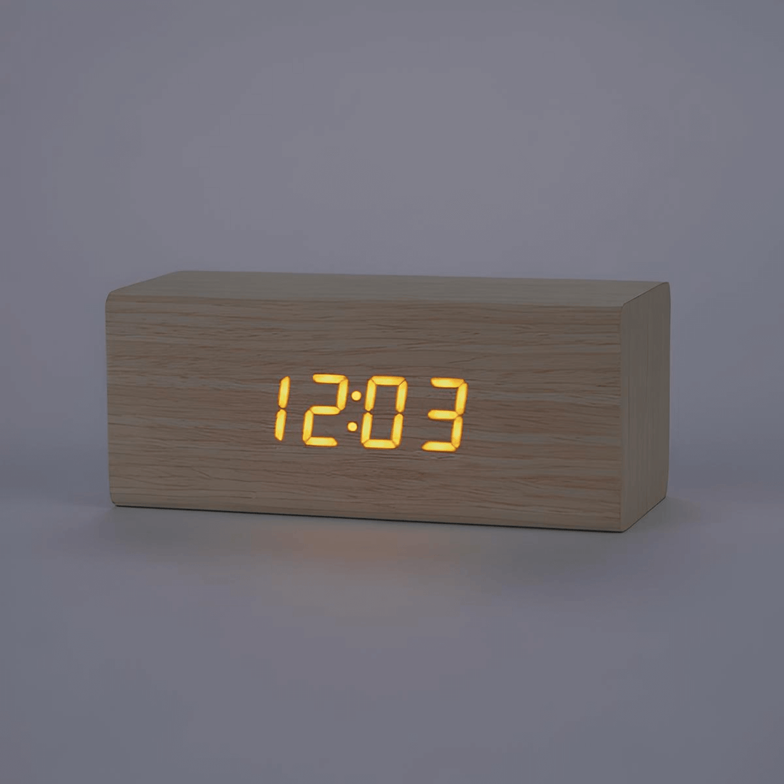 Minimalist wooden LED alarm clock displaying the time 12:03 with an elegant cube design.