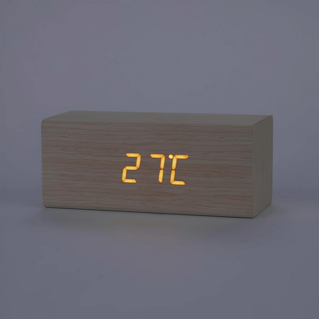 Minimalist wooden LED alarm clock with glowing temperature display in cube design.