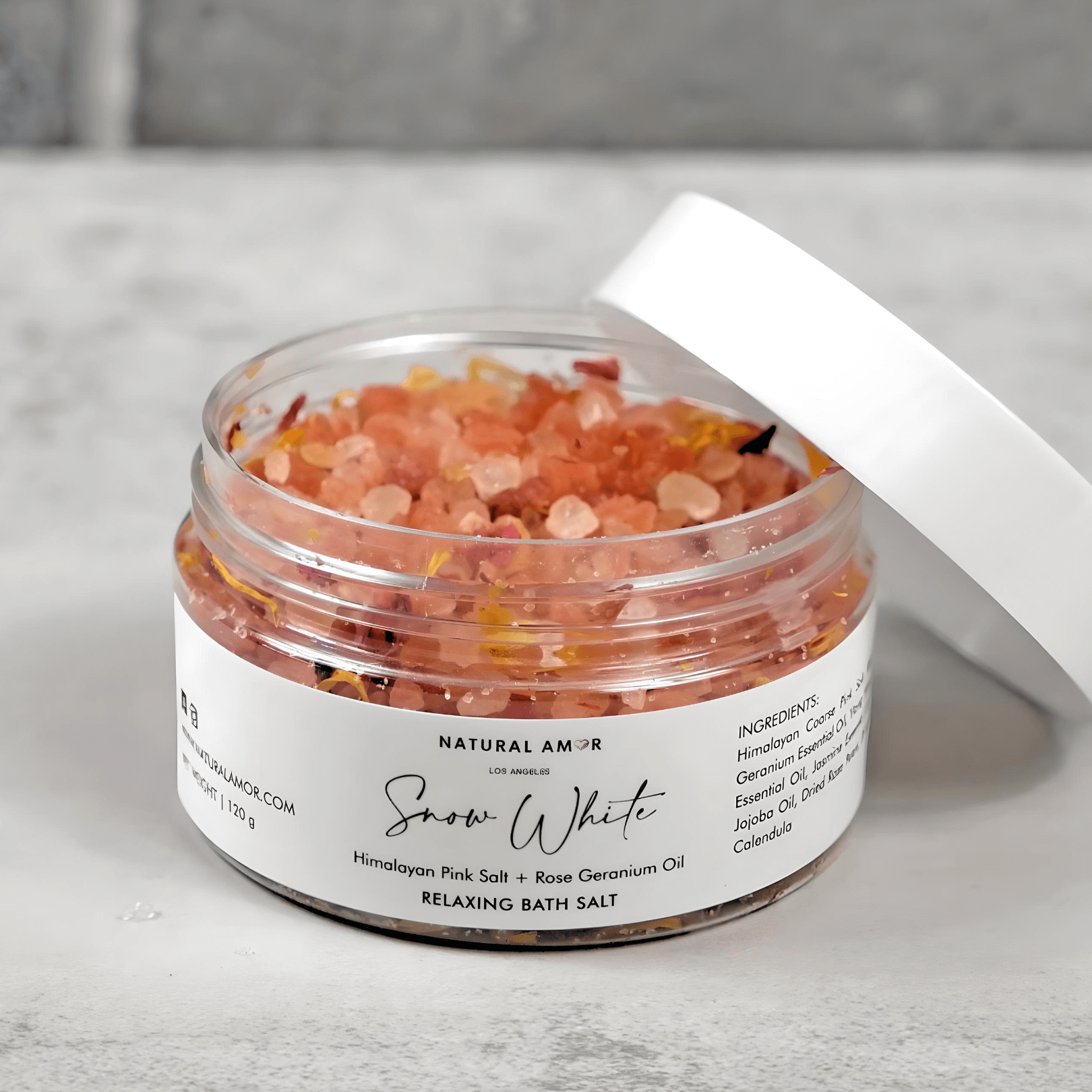 Natural Amor Snow White Relaxing Bath Salt with Himalayan pink salt and rose geranium oil, perfect for a soothing spa experience.