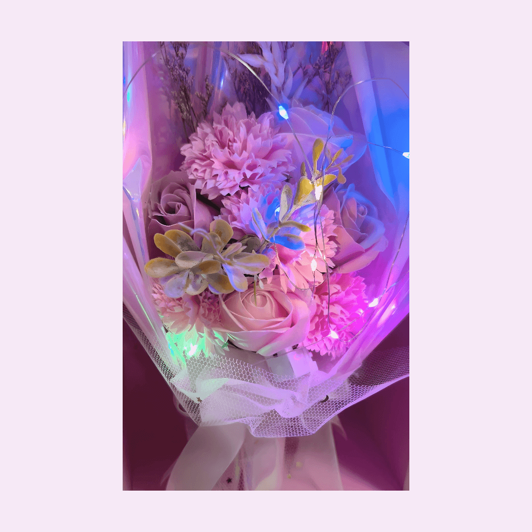 Pink flower bouquet with LED lights creating a magical ambiance, featuring soft and deep pink blooms.