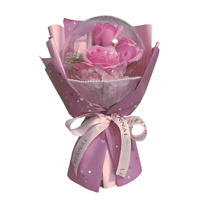 Pink rose bouquet in acrylic dome, elegantly wrapped in pink paper with decorative ribbon, ideal for gifting.