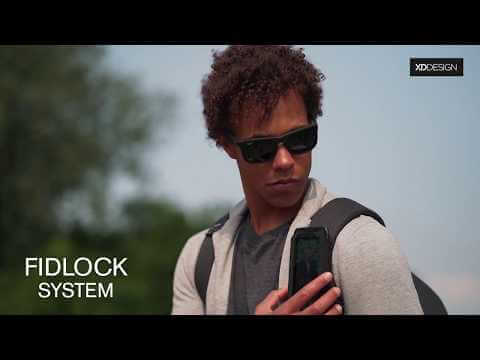 Man using the Fidlock system on the XD Design Bobby Tech Anti-Theft Backpack for secure phone access.