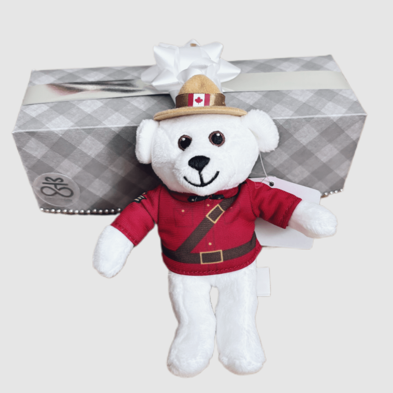 RCMP Polar Bear keychain plush, wearing Mountie outfit, with gift box background, perfect for travel and Canadian pride.