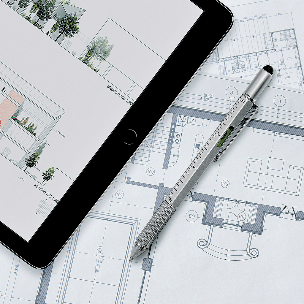 The Architect Multifunction Pen on blueprints beside an iPad, showcasing its versatile design for architects and designers.