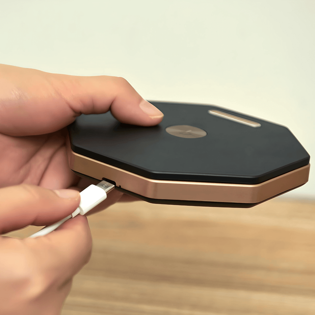 Hand connecting USB cable to an octagonal lamp charger with a sleek black and gold design.