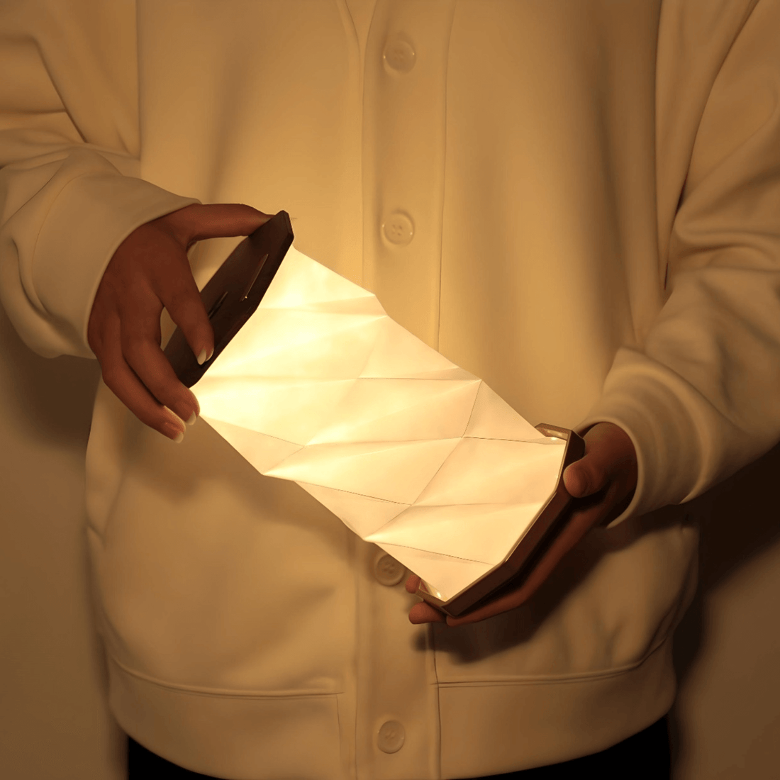 Twist Hexagon Lamp in walnut finish held by a person, featuring a modern design and soft warm light.