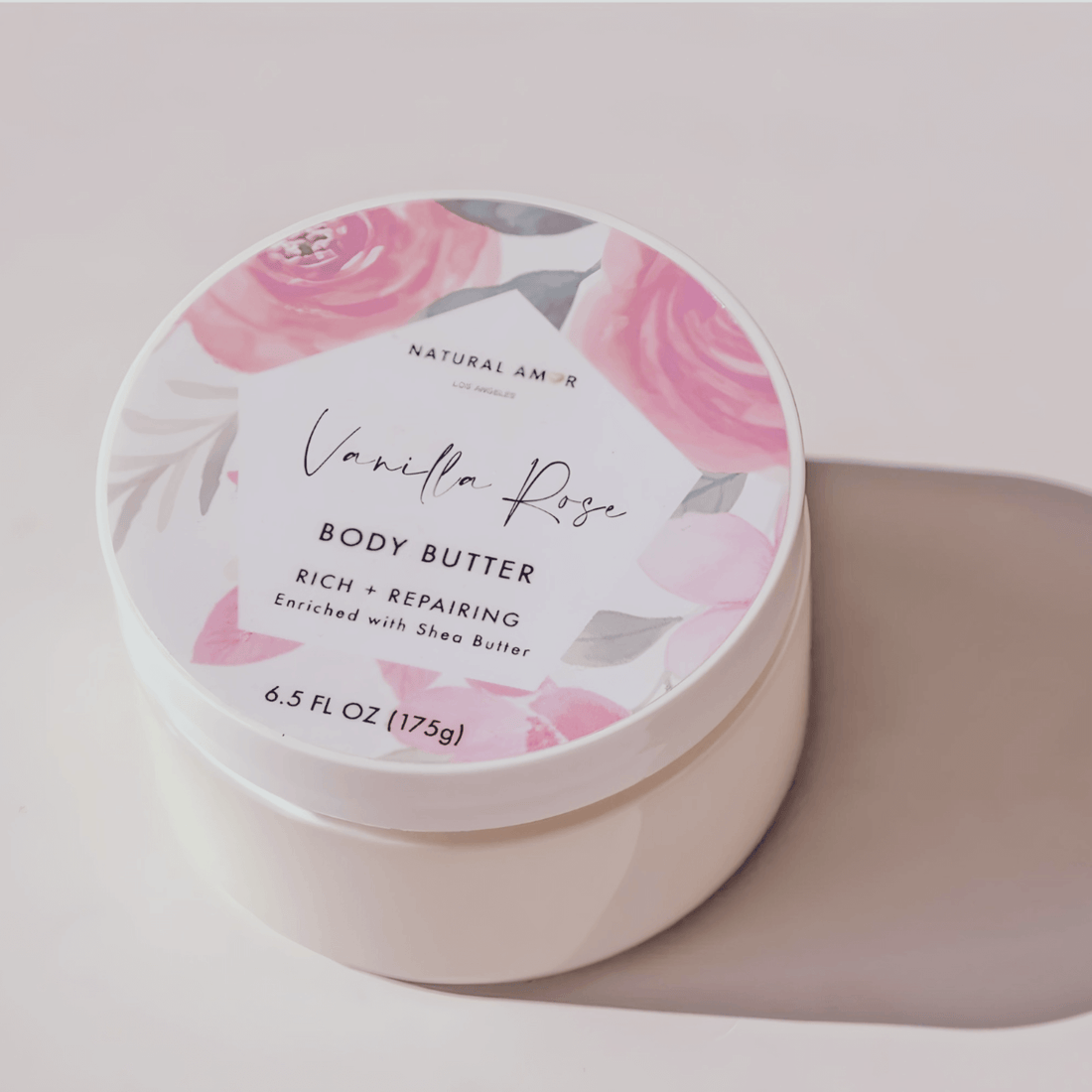 Natural Amor Vanilla Rose Body Butter in a floral container, enriched with shea butter for rich hydration.