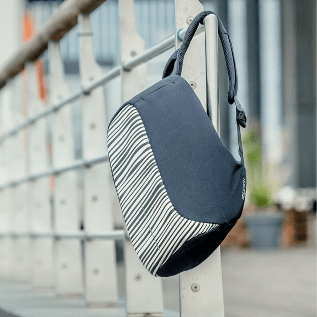 XD Design Bobby Compact Anti-Theft Backpack - Zebra hanging on a railing, showcasing unique zebra pattern and security features.